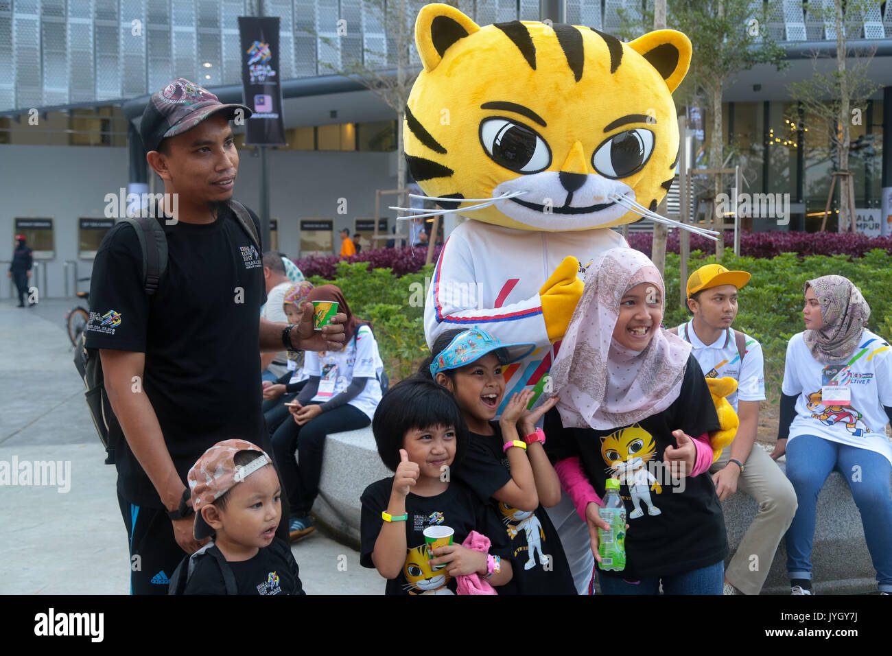 Kids are taking picture with the official tiger mascot call RIMAU on the day of official opening ceremony of 29th SEA games. Credit: Calvin Chan/Alamy Live News Stock Photo