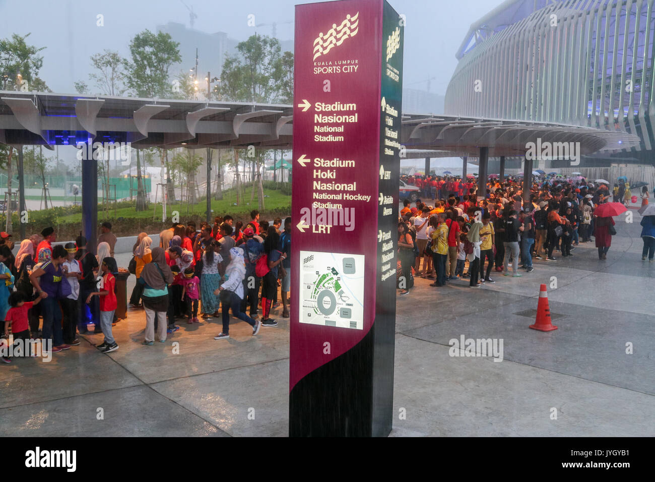 Crowd go under the shade when heavy rain suddenly pour down during the opening ceremony of 29th SEA games. Credit: Calvin Chan/Alamy Live News Stock Photo