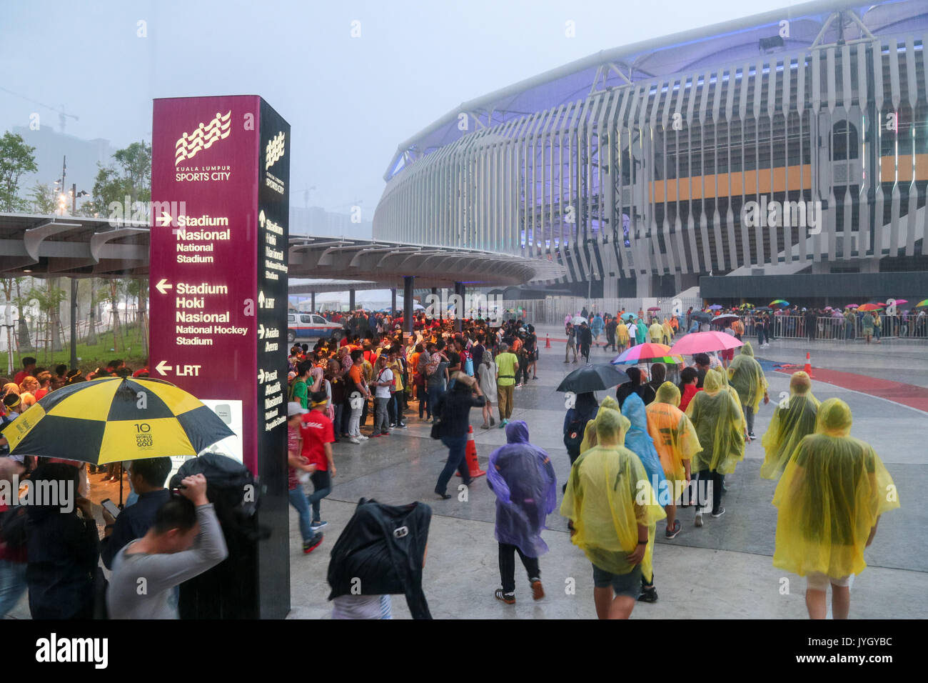 Crowd wading through the heavy rain during the opening ceremony of 29th SEA games. Credit: Calvin Chan/Alamy Live News Stock Photo