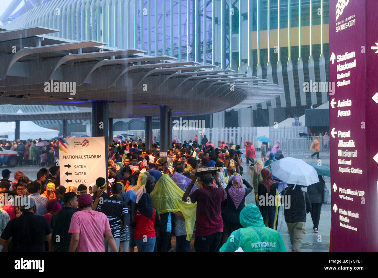 Crowd wading through the heavy rain during the opening ceremony of 29th SEA games. Credit: Calvin Chan/Alamy Live News Stock Photo