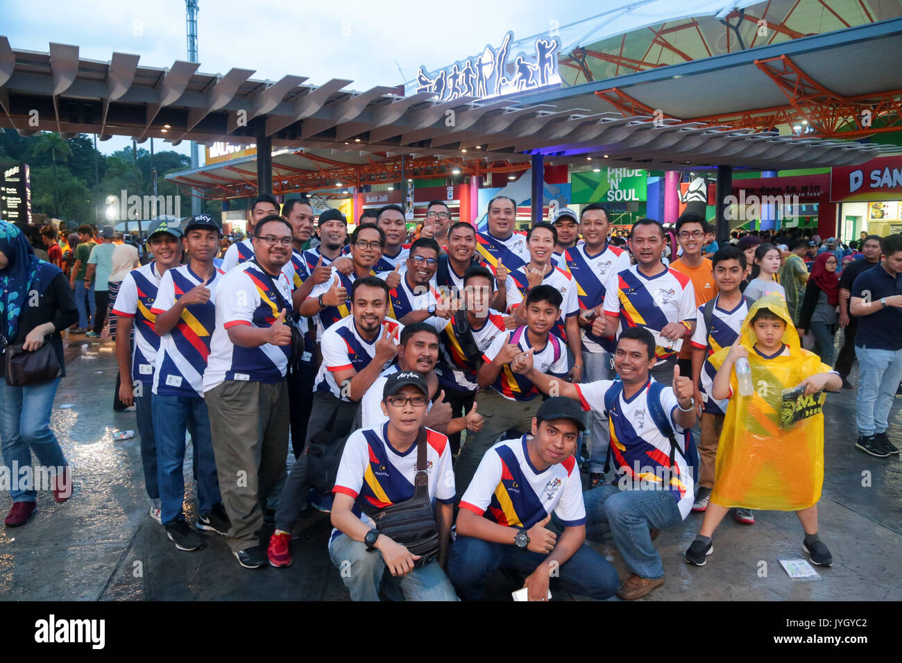 Group of Malaysian wearing white colour SEA games official T-shirts outside the LRT statioin near national stadium during the opening ceremony of 29th SEA games. Credit: Calvin Chan/Alamy Live News Stock Photo