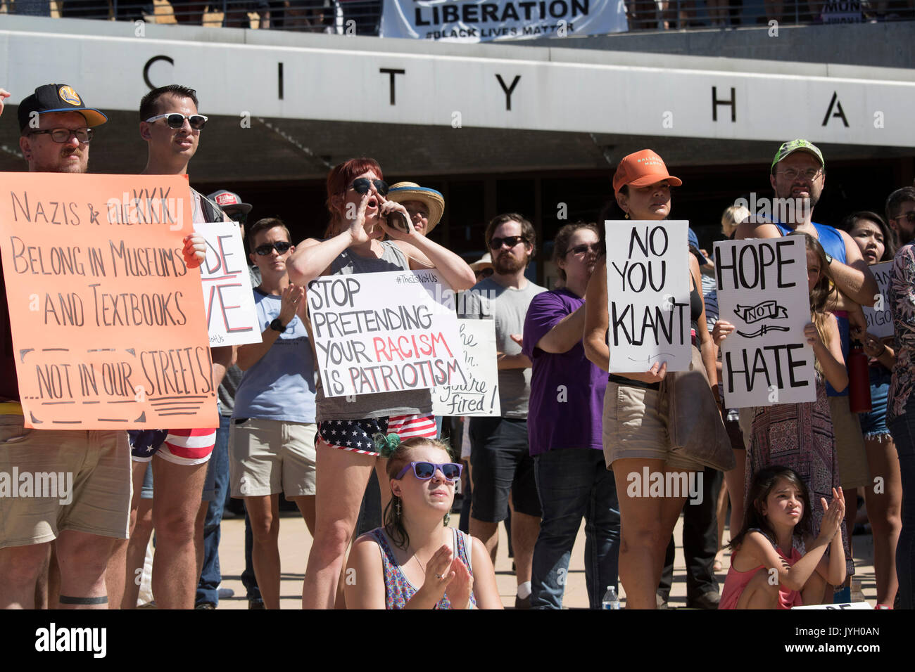 Activists and protesters converge on City Hall for a hot two-hour rally against racism and President Donald Trump's apparent insensitive comments about recent Charlottesville violence that left one dead. About 1,000 gathered in the August Texas heat. Stock Photo