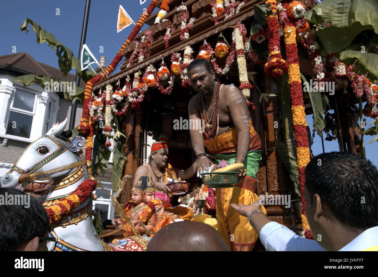 London, UK. 20th Aug, 2017. The London Sri Murgan Temple in East London celebrated the Chariot festival, stating with the blessing of the deities inside the temple, after taken into to a chariot where huge crowds gathering to follow it trough the streets of East Ham, in a colorful rainbow of colours, food was blessed by the priest and passed back for the people to take home and eat Credit: Paul Quezada-Neiman/Alamy Live News Stock Photo