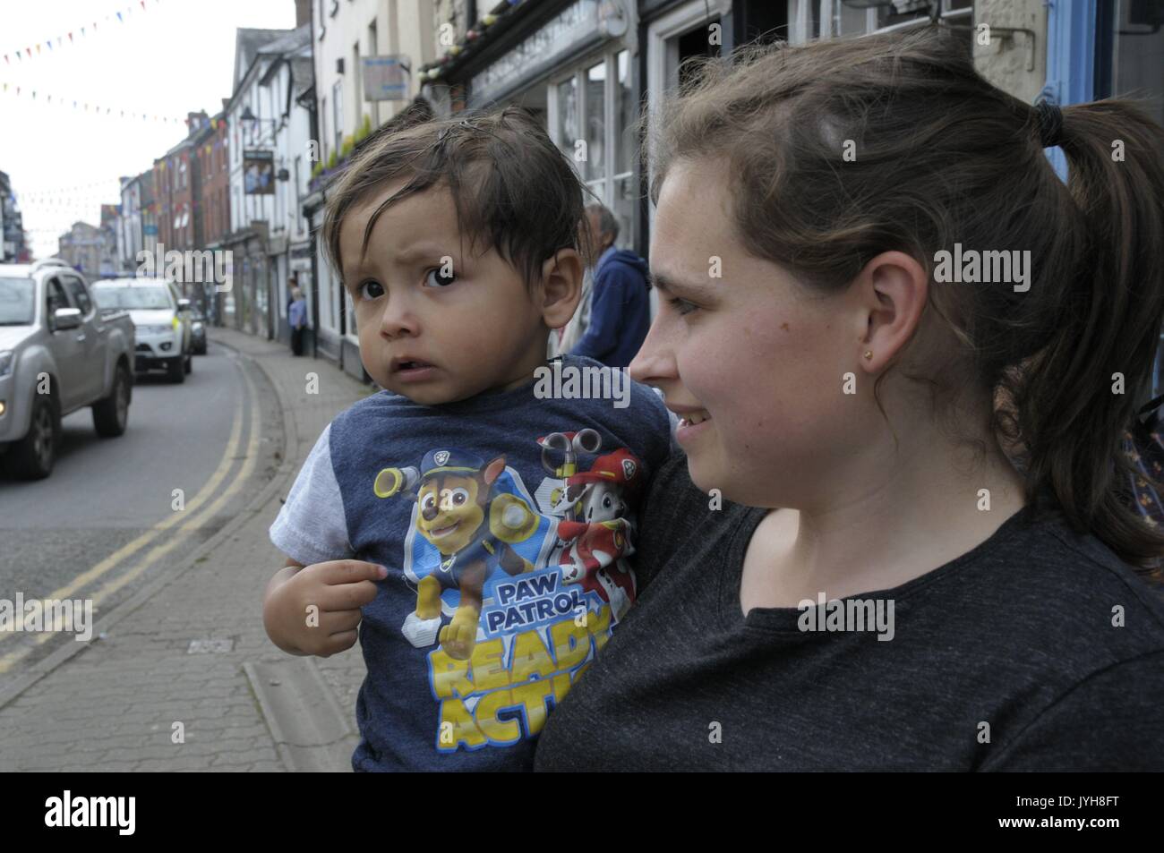 Kington, , UK. 20th Aug, 2017. The Herefordshire market town of Kington came to a standstill while a parade of vintage vehicles made their way to the Kington Vintage Club's 25th Annual Show. Natalie Compton and her two year old son Oscar watch the parade go through. Credit: Andrew Compton/Alamy Live News Stock Photo