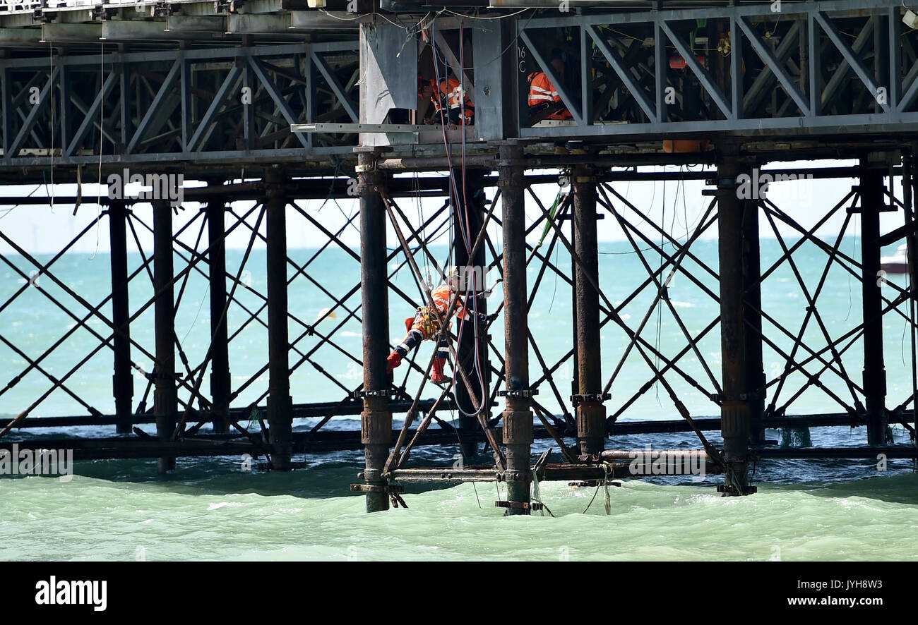 Brighton, UK. 20th Aug, 2017.; UK Weather. Workmen underneath Brighton Pier on a beautiful sunny day with temperatures expected to reach 23 degrees in some parts of the South East today Credit: Simon Dack/Alamy Live News Stock Photo
