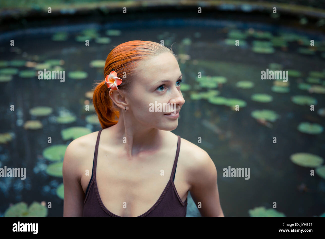 Portrait of red young woman with flower Stock Photo - Alamy