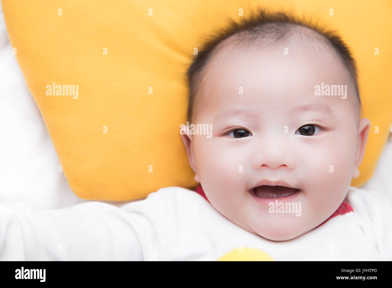 smiley asian baby boy wearing white jumpsuit Stock Photo Alamy
