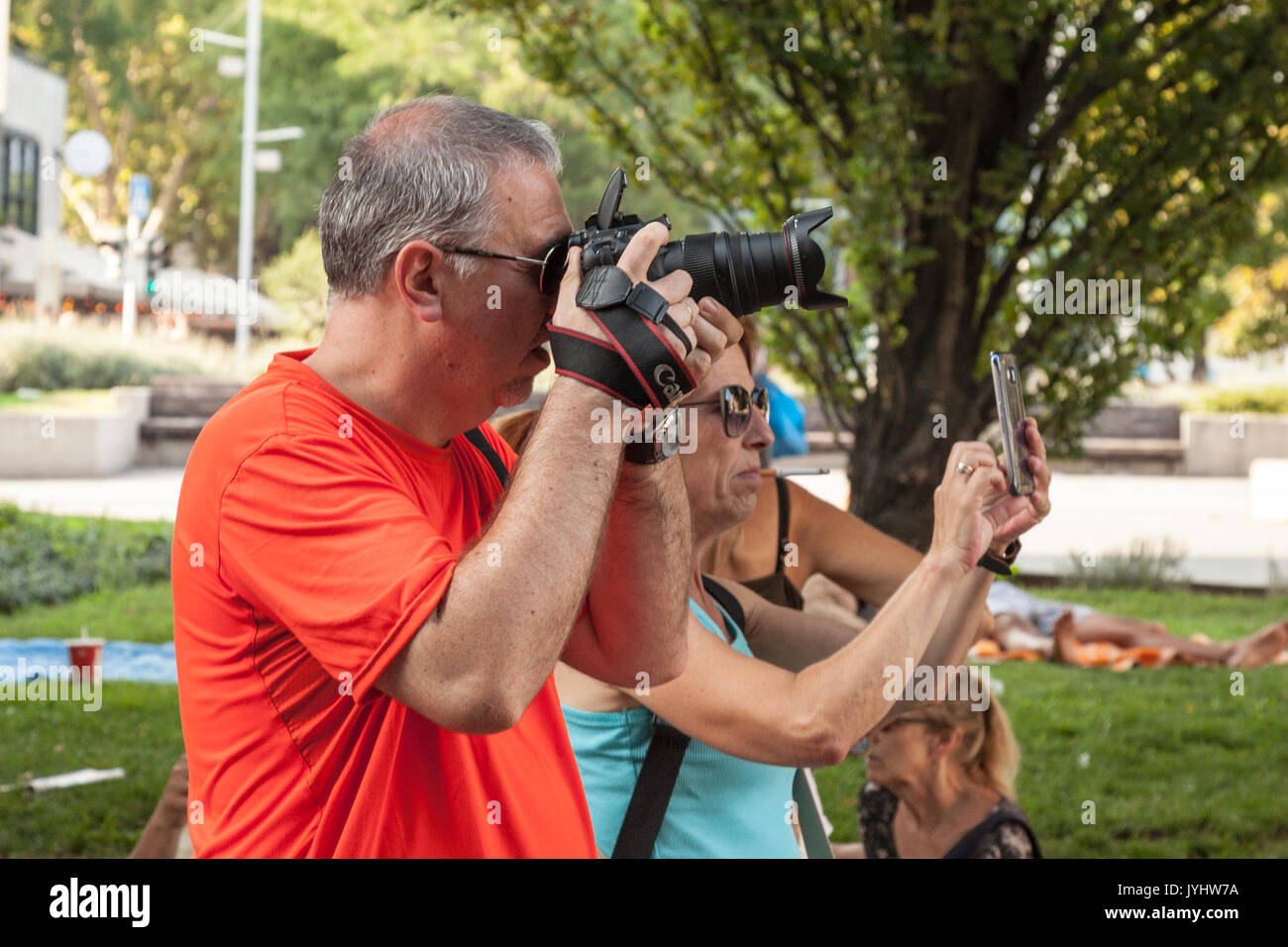 BUDAPEST, HUNGARY - AUGUST 11, 2017: Two people taking pictures in a Budapest park, one using a semi professional DSLR camera, the other using an amat Stock Photo