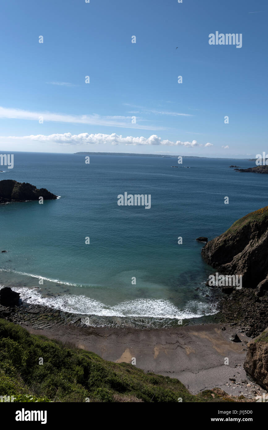 From La Coupee, a 300-foot drop narrow causeway in the Isle of Sark towards Guernsey in the distance in the Channel Islands, Britain Stock Photo