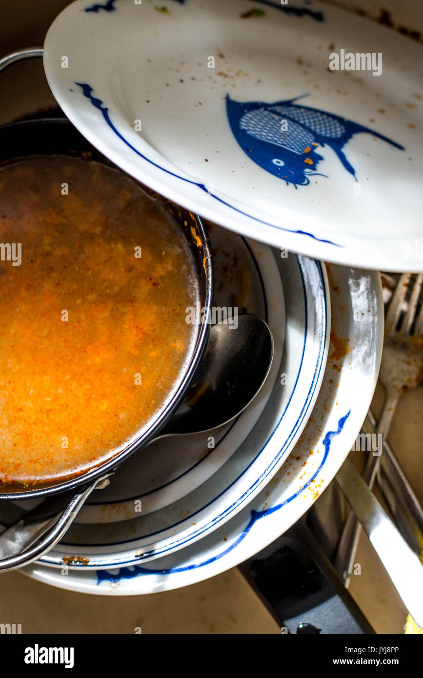 Stack Of Dirty Dishes Waiting To Be Washed In A Kitchen Sink Stock Photo