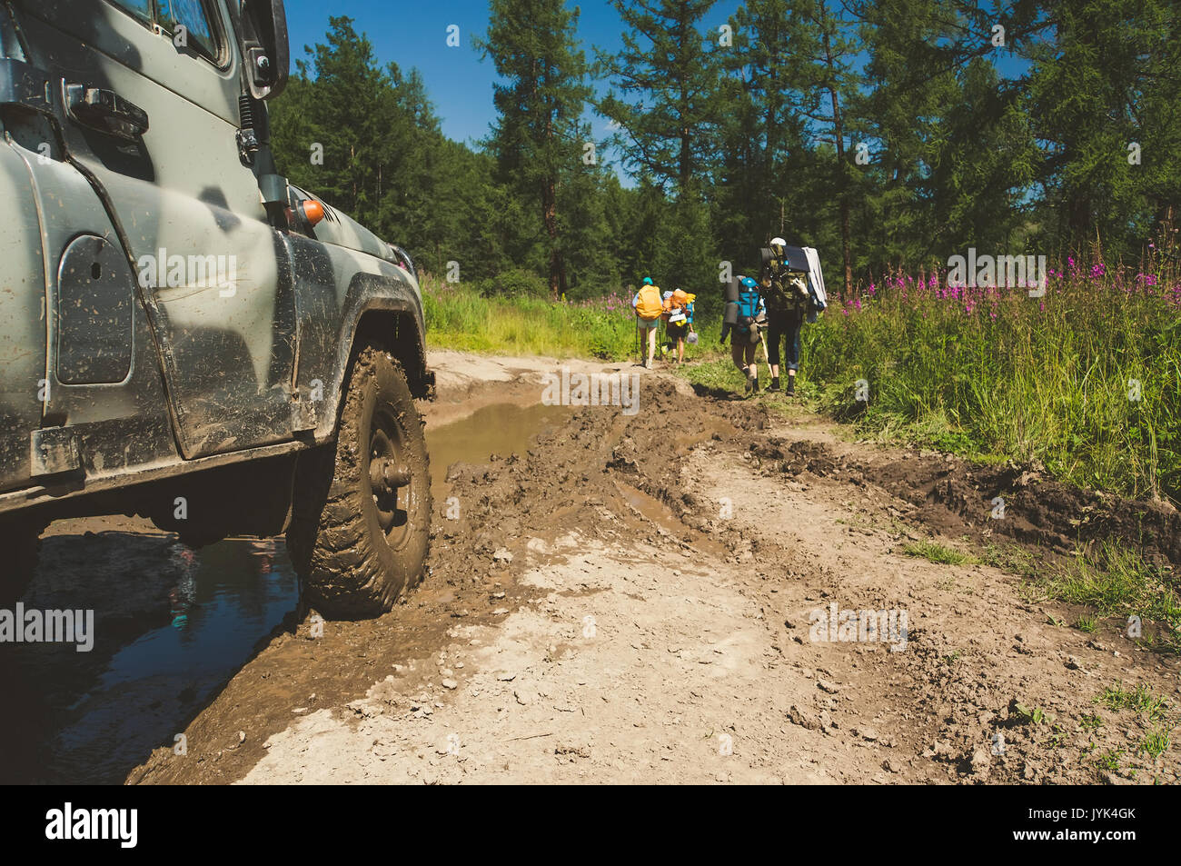 Old Russian off-road car is getting ready to move the obstacle in form of a large muddy puddles on the road impassable. Car ATV for difficult terrain. Stock Photo