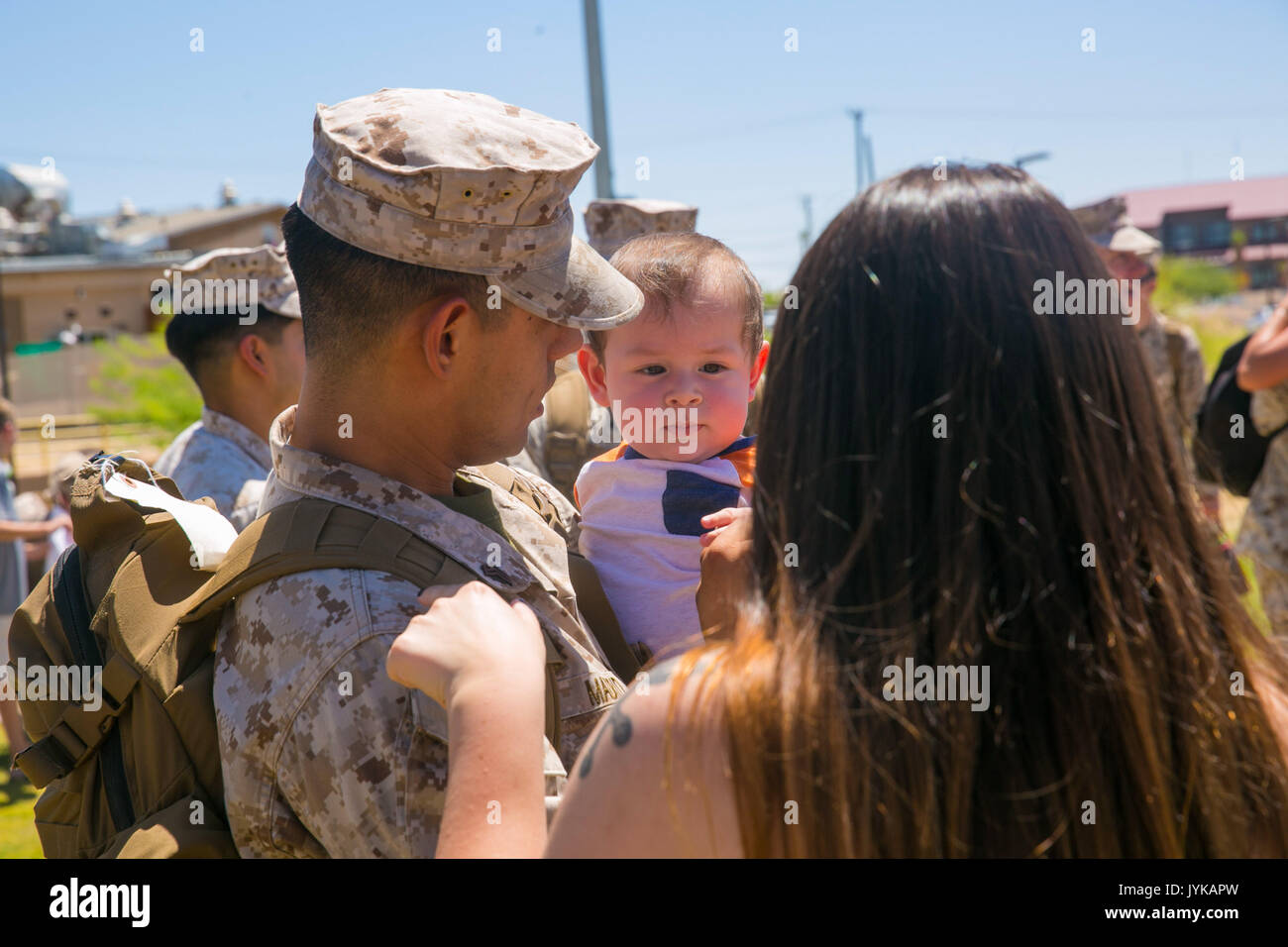 Sgt. Krystian Madrid, intelligence specialist, 7th Marine Regiment, holds his son following his unit’s homecoming at Victory Park aboard the Marine Corps Air Ground Combat Center, August 17, 2017. 7th Regiment Marines completed a nine month deployment as the command element of Special Purpose Marine Air-Ground Task Force – Crisis Response – Central Command 17.1. (U.S. Marine Corps photo by Lance Cpl. Isaac Cantrell) Stock Photo