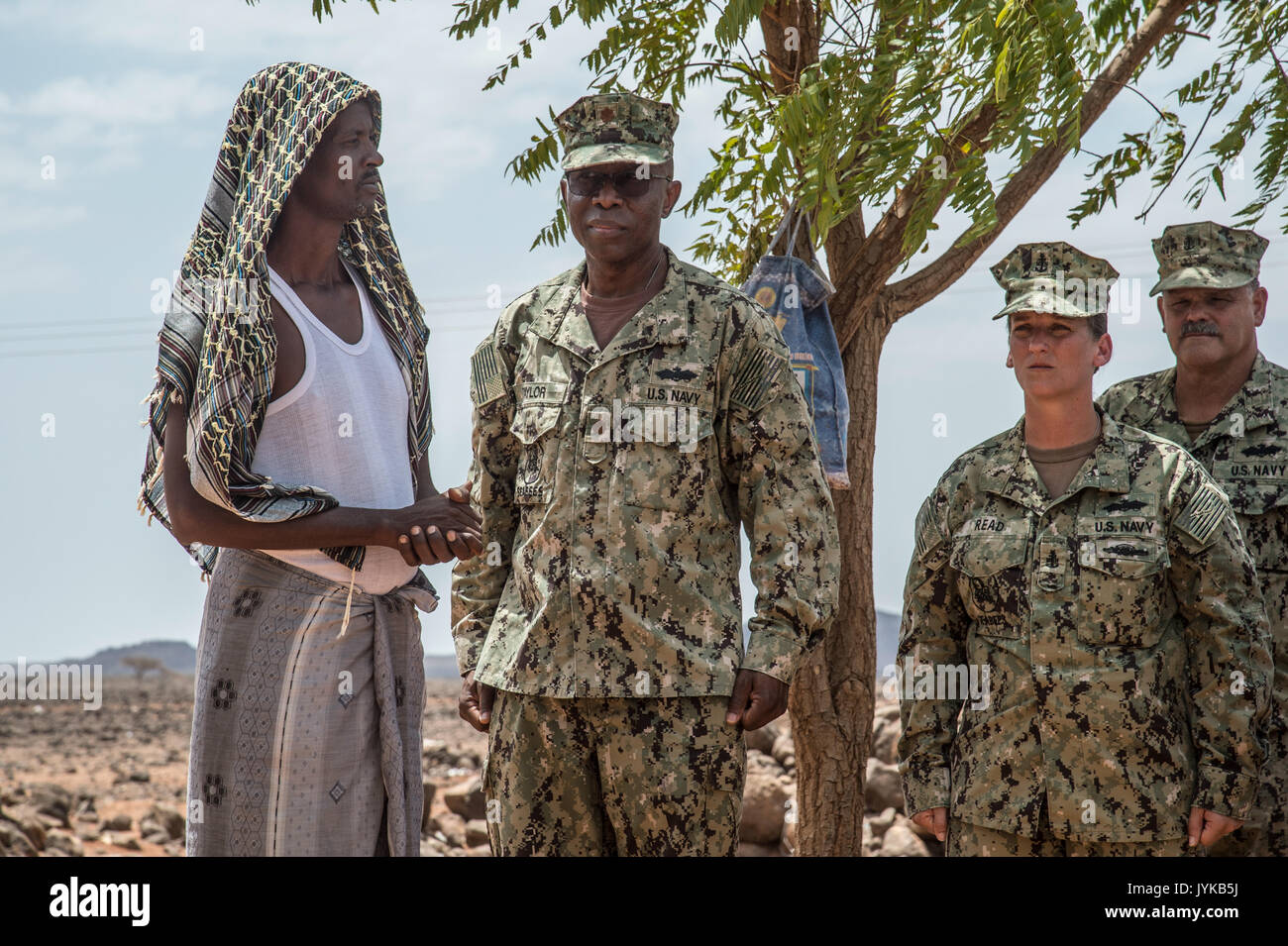 U.S. Navy Lt. Cmdr. James O. Taylor, commander of Naval Mobile Construction Battalion 133, is introduced to Village Chief Hassan Diama as Seabees assigned to Combined Joint Task Force-Horn of Africa gathered on a construction in the Arta region, Djibouti, during a flag dedication ceremony where they are building a medical center, Aug. 17, 2017. The project was started by NMCB 1 and is being relieved by NMCB 133 who will continue working on the project with plans of completion in 2018. (U.S. Air National Guard photo by Tech. Sgt. Joe Harwood) Stock Photo