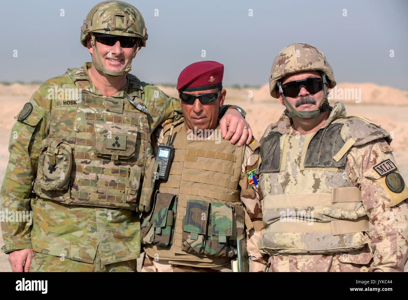 Australian Brig. Gen. Rupert Hoskin, Combined Joint Task Force-Operation Inherent Resolve, director CJ5, left, and Canadian Brig. Gen. Steve Whelan, Combined Joint Task Force-Operation Inherent Resolve, CJ7, pose for a photo with an Iraqi security forces officer during a battlefield circuit at the Besmaya Range Complex, Iraq, August 9, 2017. The Besmaya Range Complex is one of four Combined Joint Task Force - Operation Inherent Resolve building partner capacity locations dedicated to training partner forces and enhancing their effectiveness on the battlefield. CJTF-OIR is the global Coalition  Stock Photo