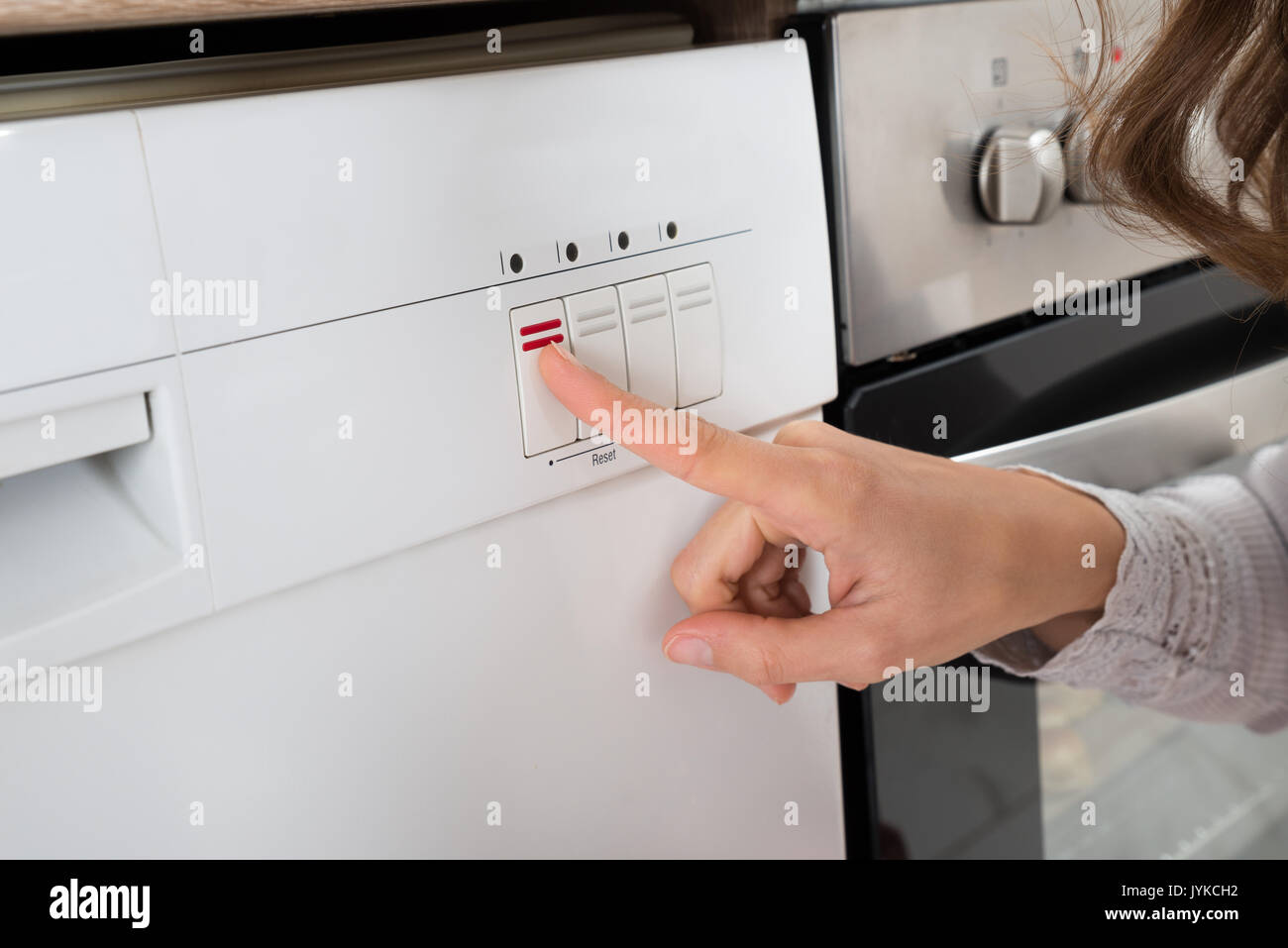 Close-up Of Person Hands Pressing Button Of Dishwasher Stock Photo