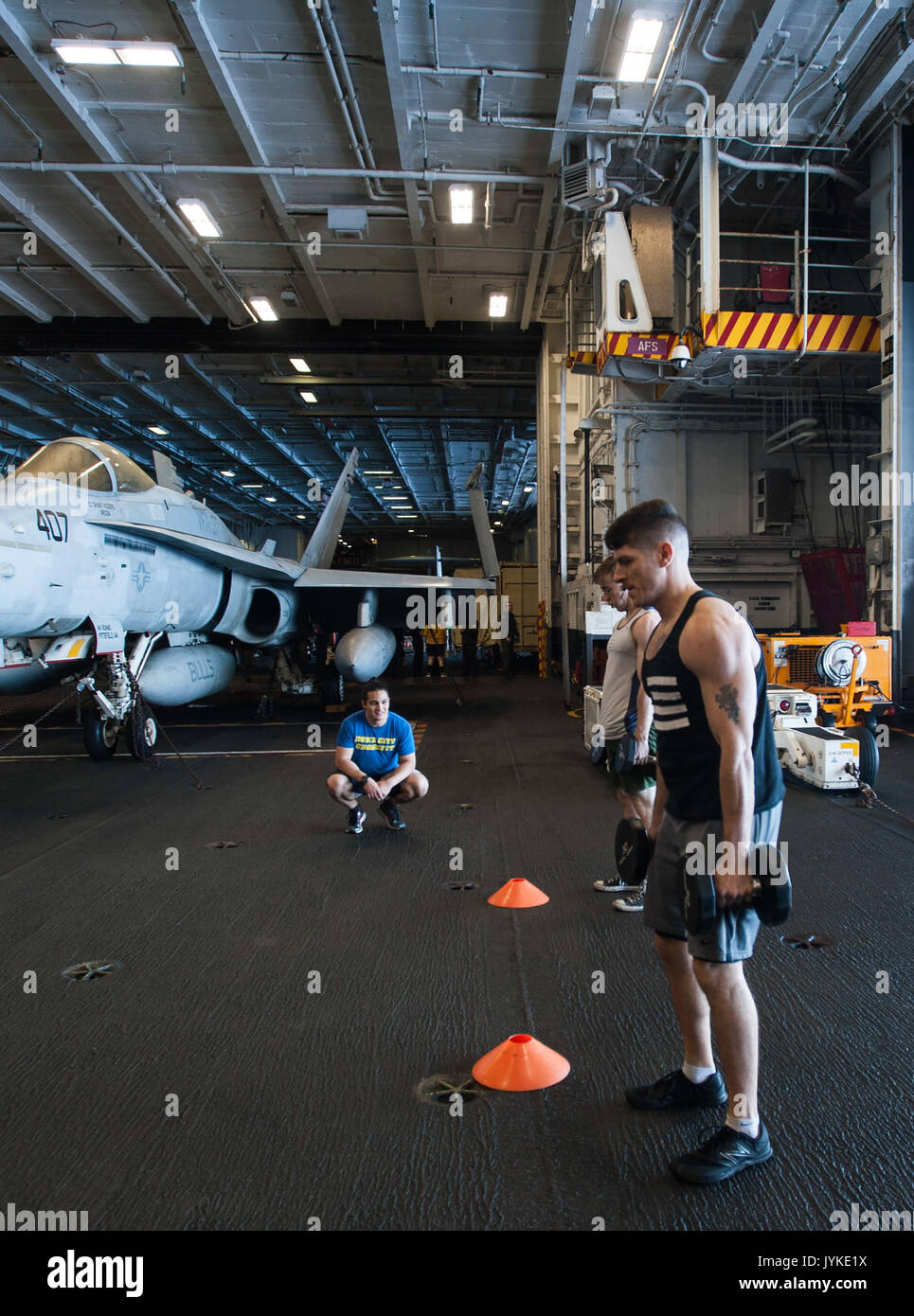 170815-N-RZ514-042 ATLANTIC OCEAN (Aug. 15, 2017) 'Fit Boss' Justin Vigil, left, hosts a 'Battle for the Dumbbell' competition in the hangar bay aboard the aircraft carrier USS George H.W. Bush (CVN 77). The ship and its carrier strike group are conducting naval operations in the U.S. 6th Fleet area of operations in support of U.S. national security interests.  (U.S. Navy photo by Mass Communication Specialist Seaman Jennifer M. Kirkman/Released) Stock Photo