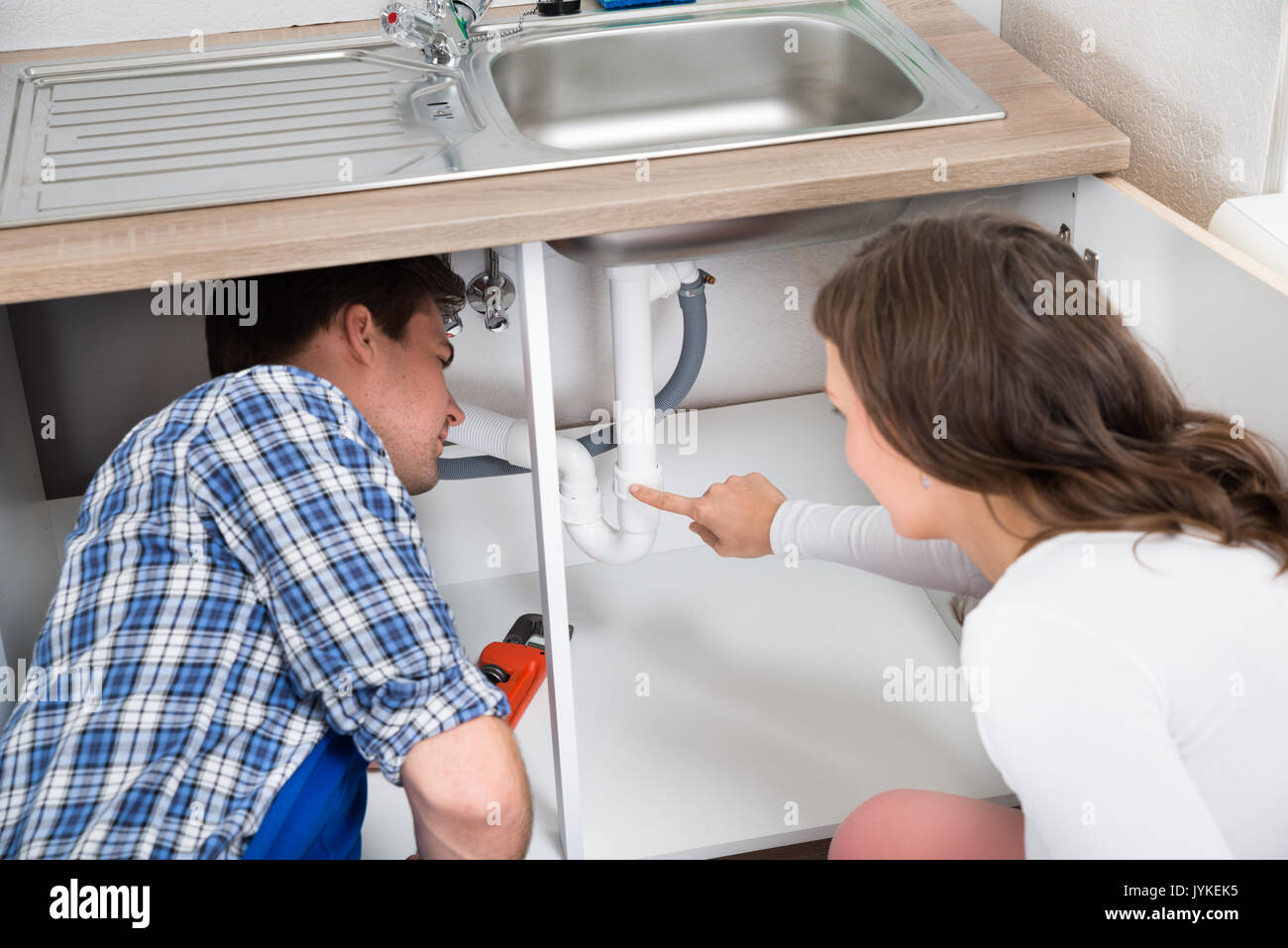 Man repairing plumbing under sink hi-res stock photography and images