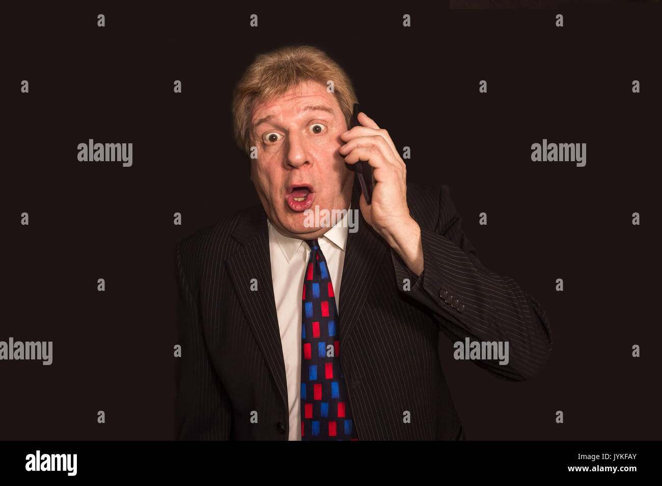 Shocking News Surprised Mature Man In Suit With Mobile Phone Stock