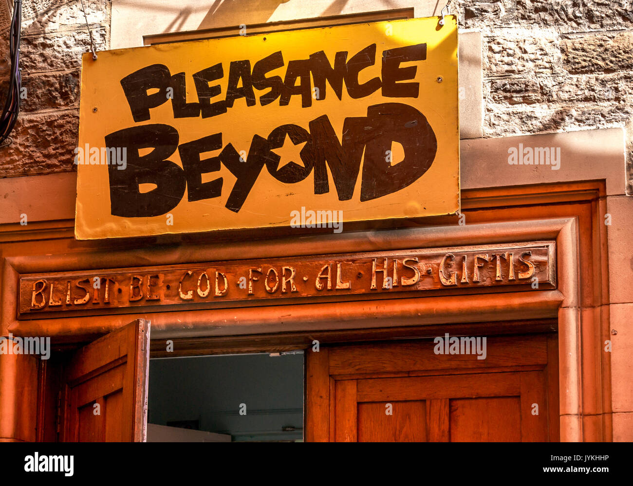 Juxtaposition of new Fringe Festival venue sign on doorway with old religious carved stone inscription, Pleasance Courtyard, Edinburgh, Scotland, UK Stock Photo
