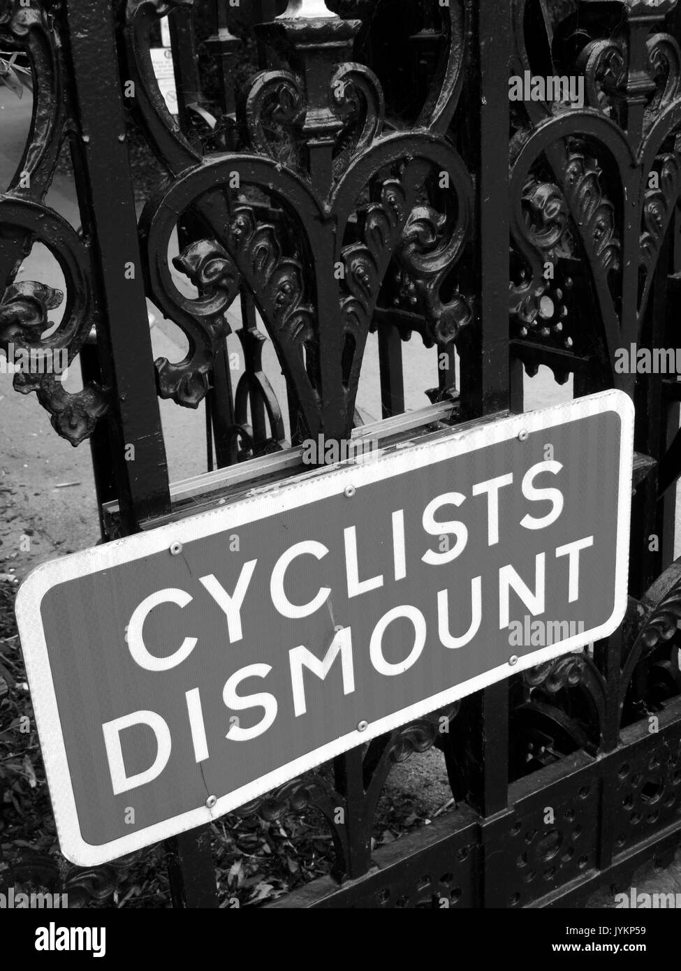 Cyclist dismount highway information sign mounted on iron railings Stock Photo