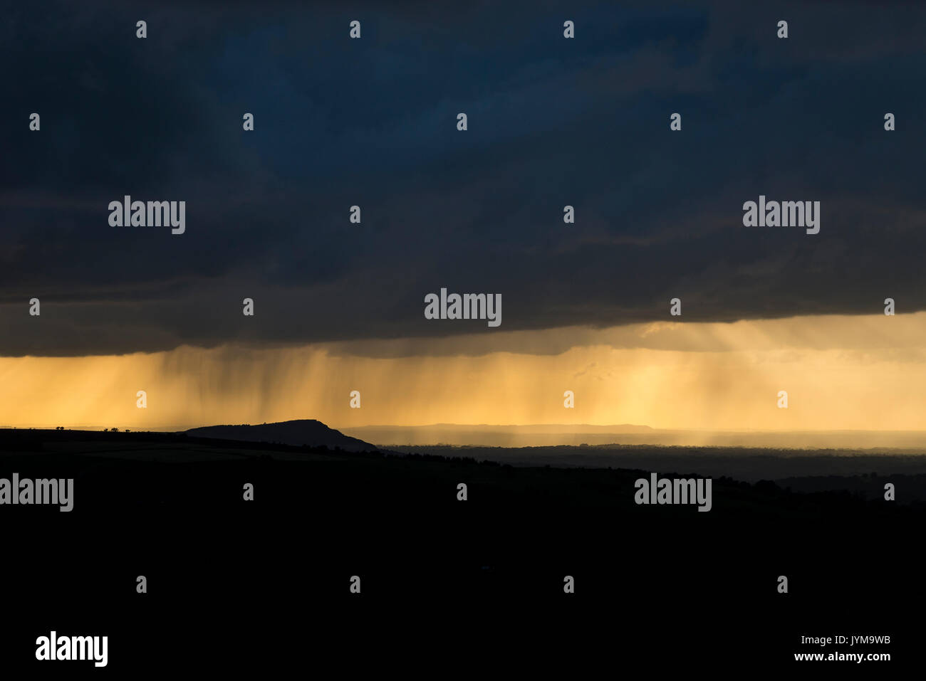 Rain clouds at sunset over the Cheshire countryside, England. Viewed from the Roaches in Staffordshire. Stock Photo