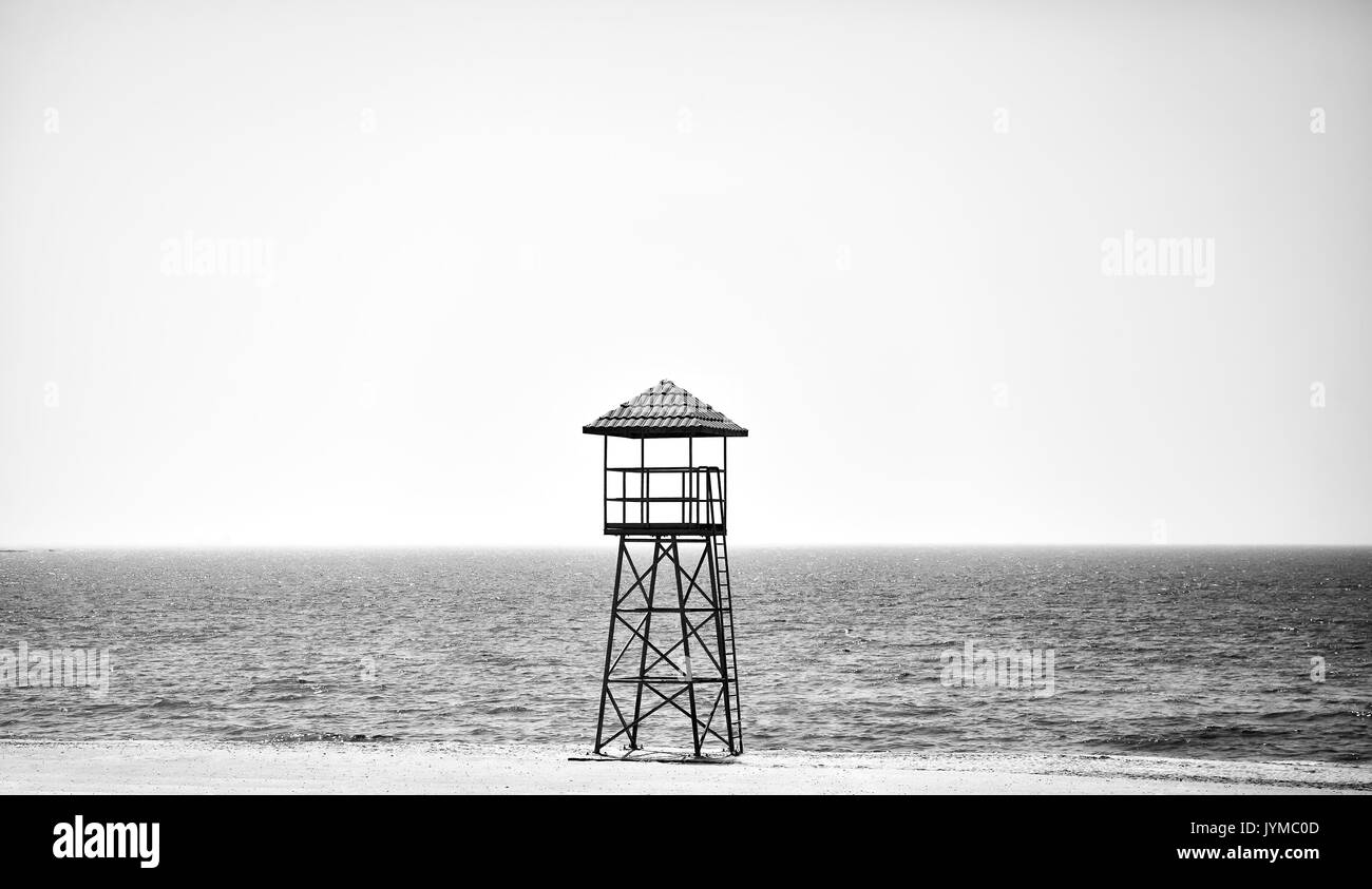 Black and white picture of a lifeguard tower on an empty beach. Stock Photo