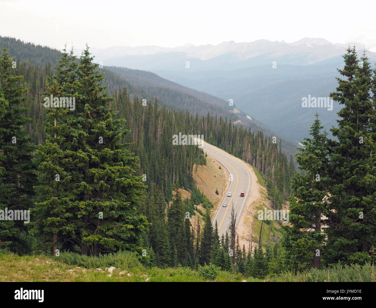 several cars on the road through the mountains in Colorado Stock Photo