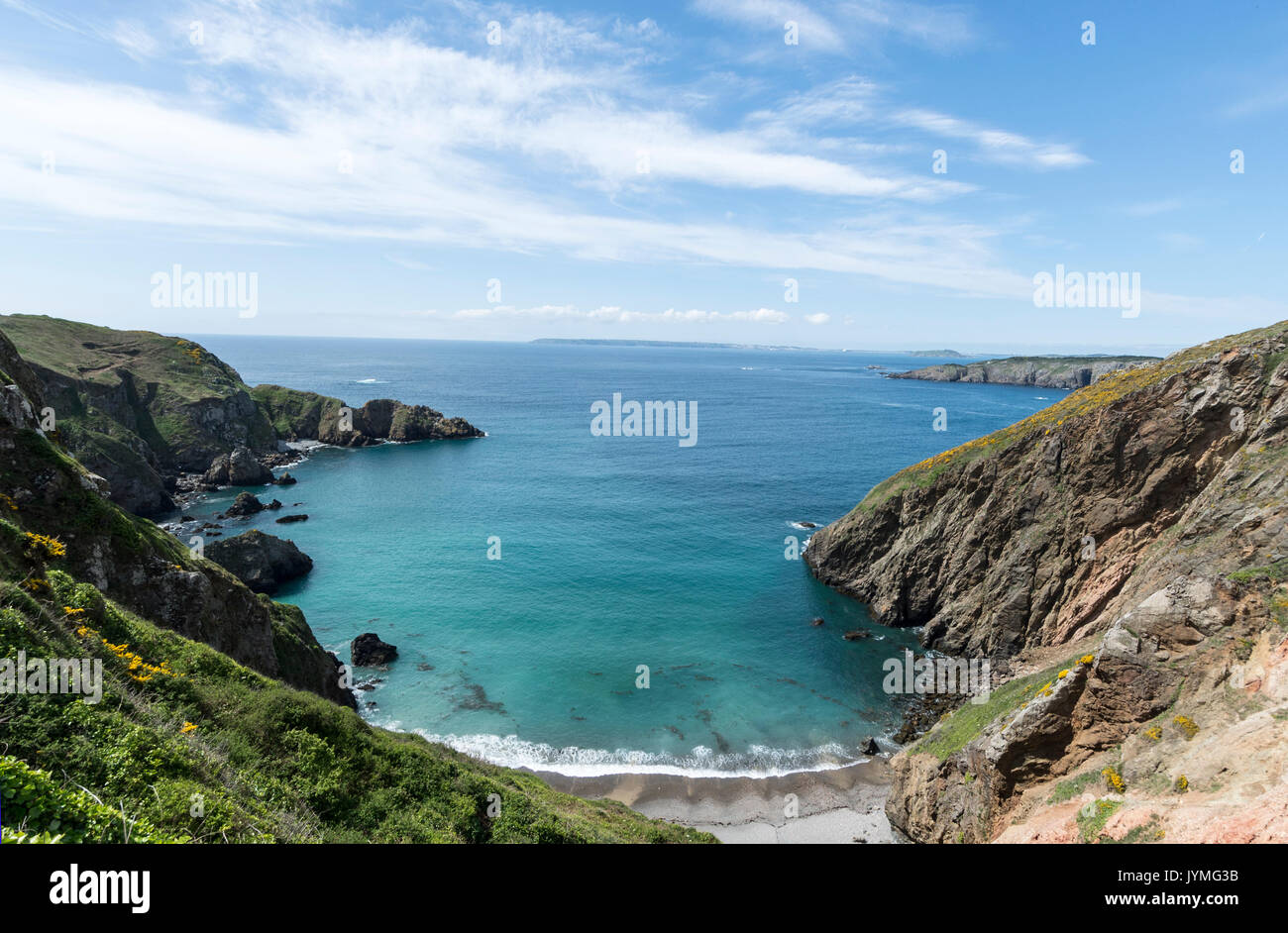 From La Coupee , a 300 foot drop narrow causeway in the Isle of Sark towards Guernsey in the distance in the Channel Islands, Britain Stock Photo