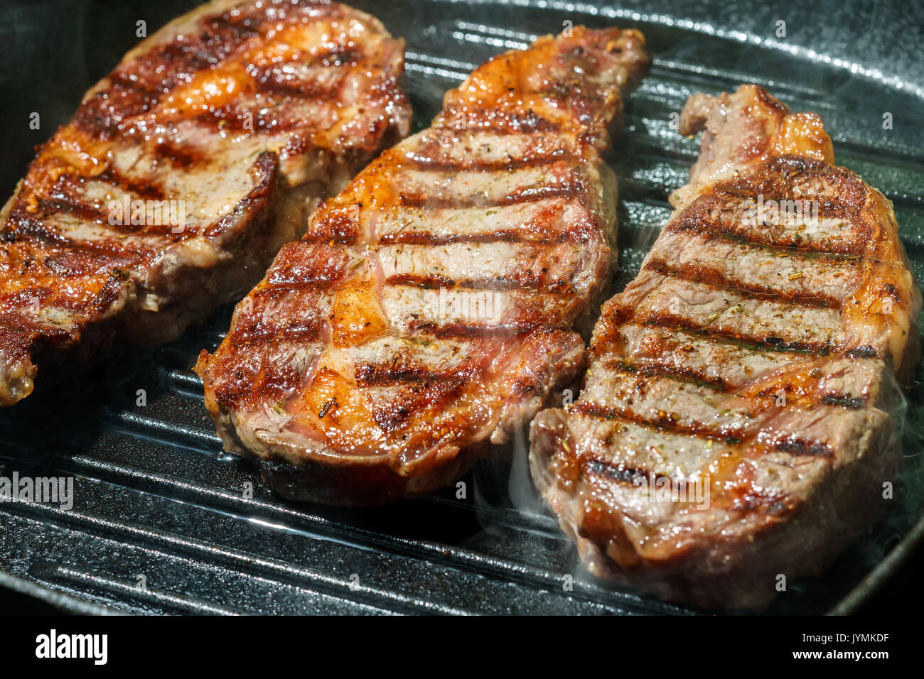 Raw Ribeye Steak with Herbs and Spices, frying on grill pan Stock Photo Alamy