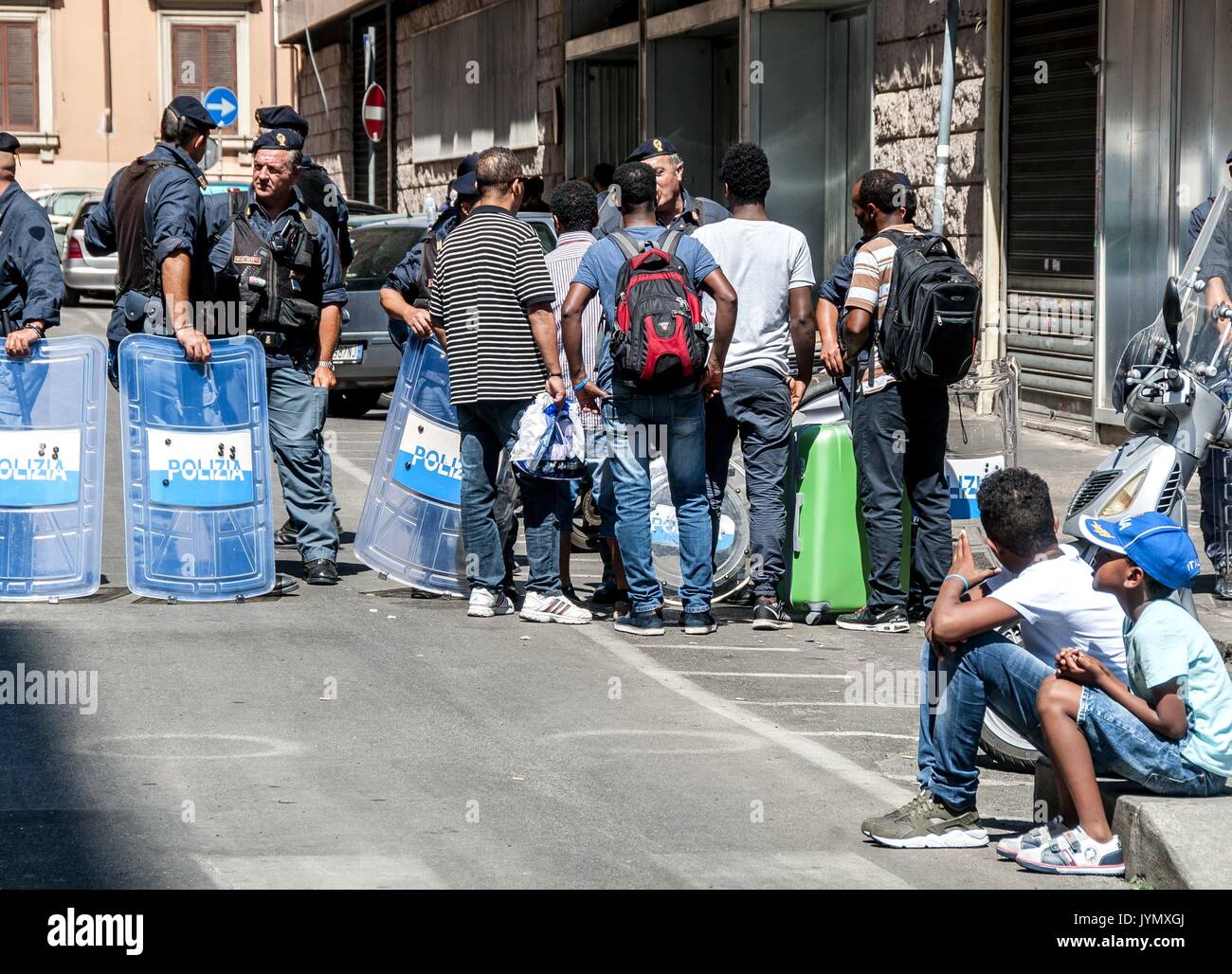 Cleared a palace in Independence Square in Rome near Termini station. It had been occupied in October 2013 by hundreds of Eritrean and Somali refugees. More than 500 law enforcement officers used for clearing. Former occupants were raised on 5 police buses and also on several public bus buses and were taken to the identification center. Some of them blocked for a few minutes the road to Termini Station and immediately armored (about 23 plus a hydrant) moved to be used against those who protested. Again, no alternative solution has been proposed for expelled refugees. In the street a thousand p Stock Photo