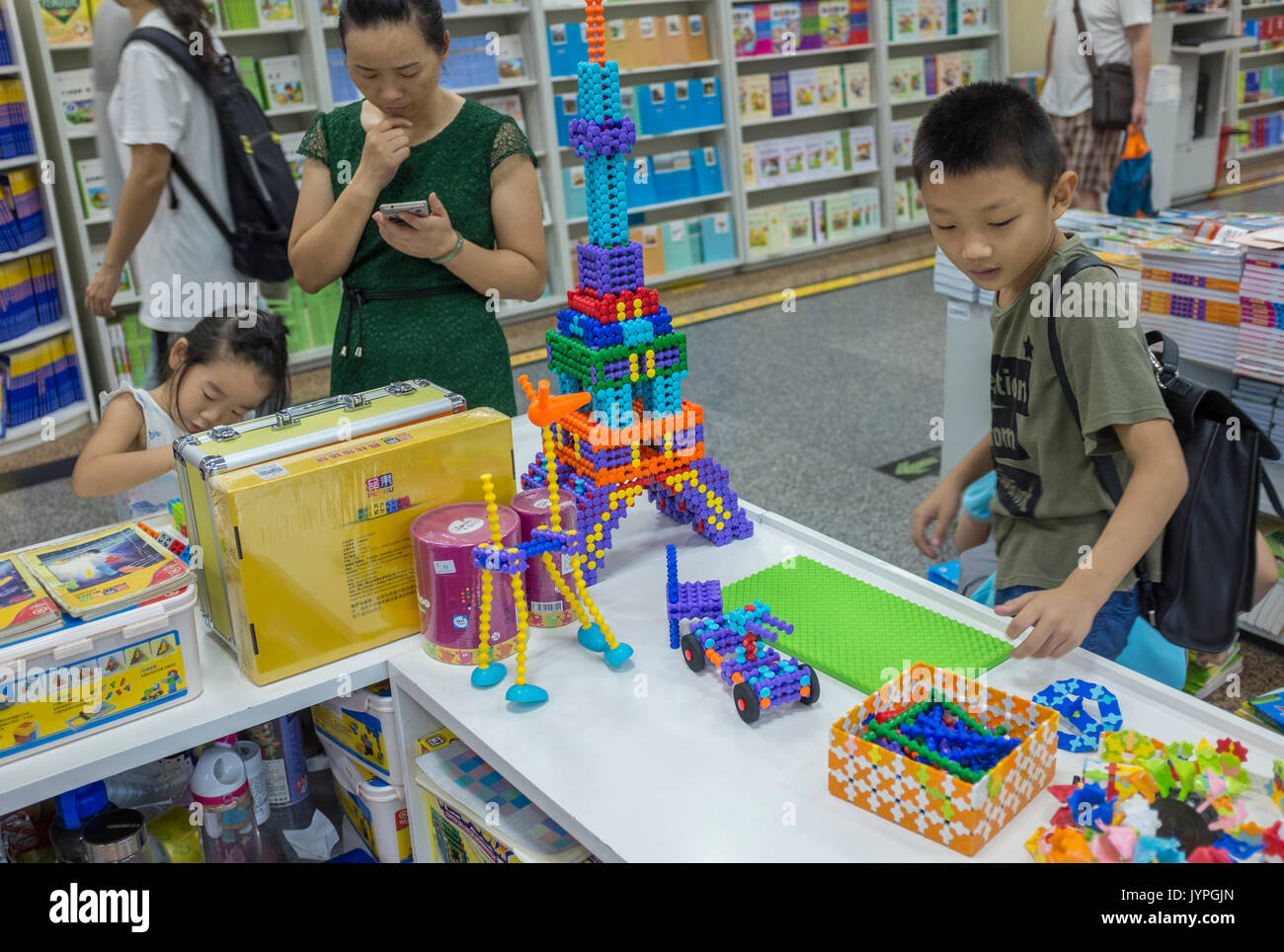 Children play Chinese-made plastic construction toys similar to LEGO in a bookstore in Beijing, China. 19-Aug-2017 Stock Photo