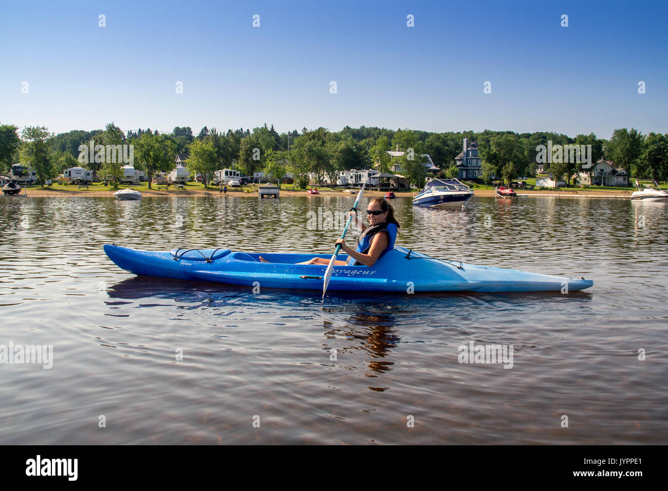 St-Gabriel-de-Brandon, Canada-20 July 2017 : woman kayaking alone at Maskinonge Lake at summer time in front of the beach Stock Photo