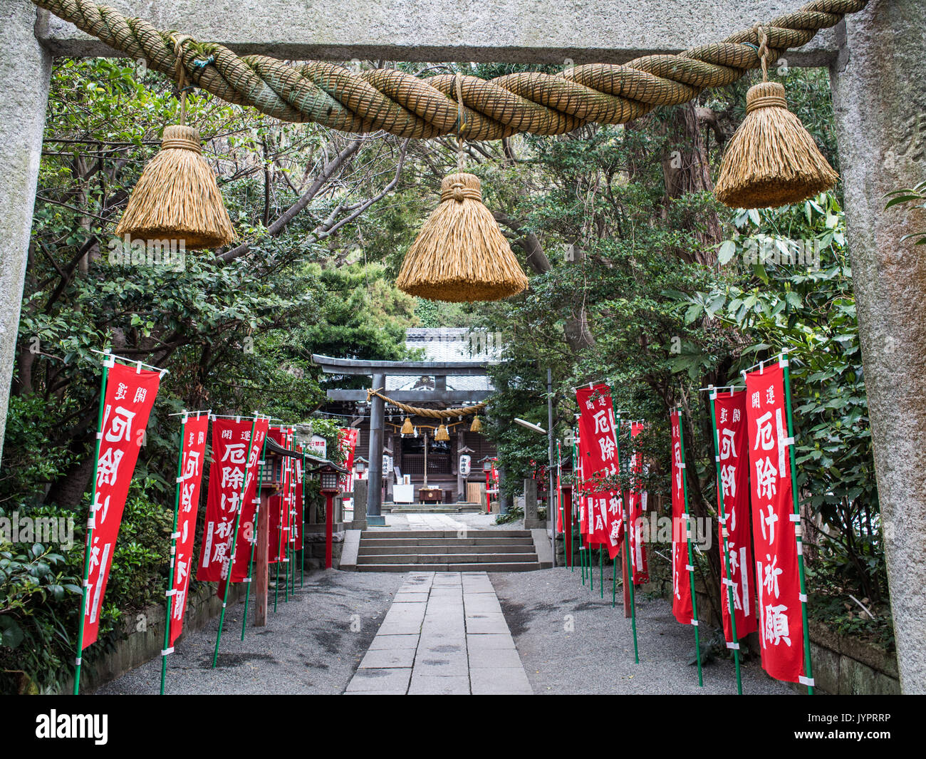 Shimenawa tassel made from braided rice straw rope, strung under the torii at the entrance to Yakumo Jinja , Kamakura, Japan. Stock Photo