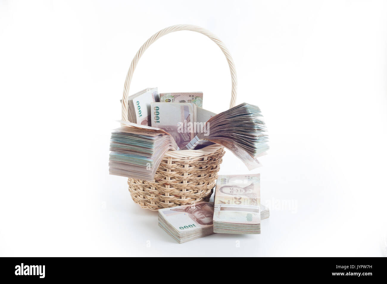 Heap of bunches of Thai baht (THB) banknotes in Straw wicker basket. Thailand currency. Stock Photo