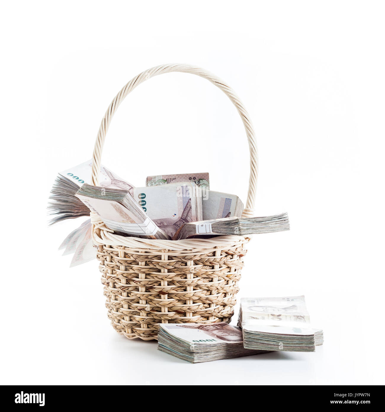 Bunches of Thai baht (THB) banknotes in Straw wicker basket. Thailand currency. Stock Photo