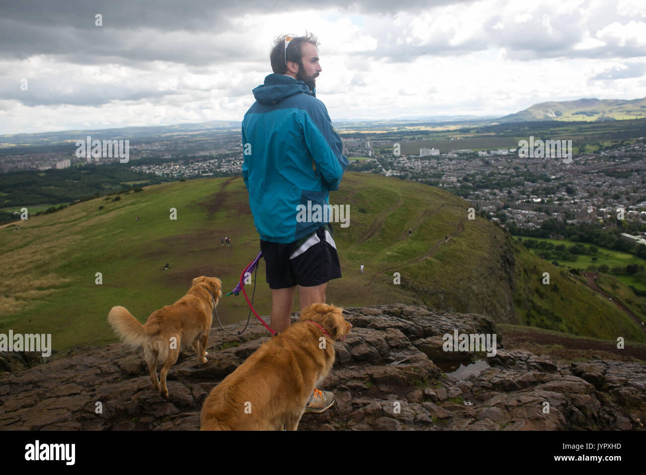 A dog walker on Arther's Seat. The peak of King Arthur's Seat is a popular destination for both locals and tourists. The peak and souronding rocky hil Stock Photo