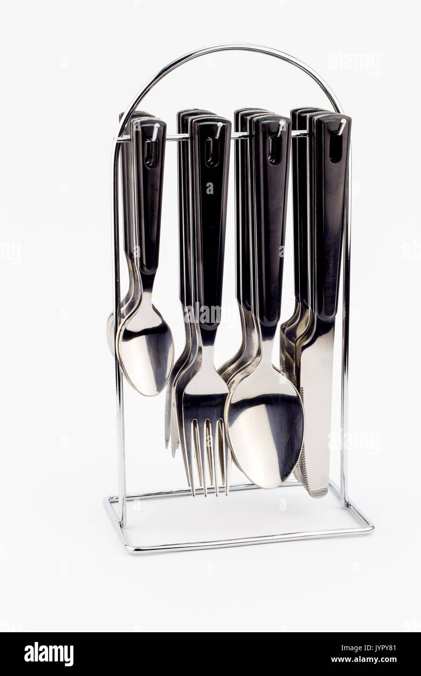 Knives, forks and spoons with black handles hanging on metal stand