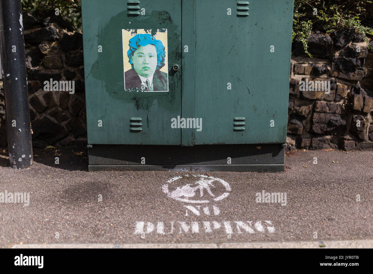North Korean leader Kim Jong Un as Andy Warhol's Marilyn Monroe on poster, with No Dumping sign on pavement in front. Stock Photo