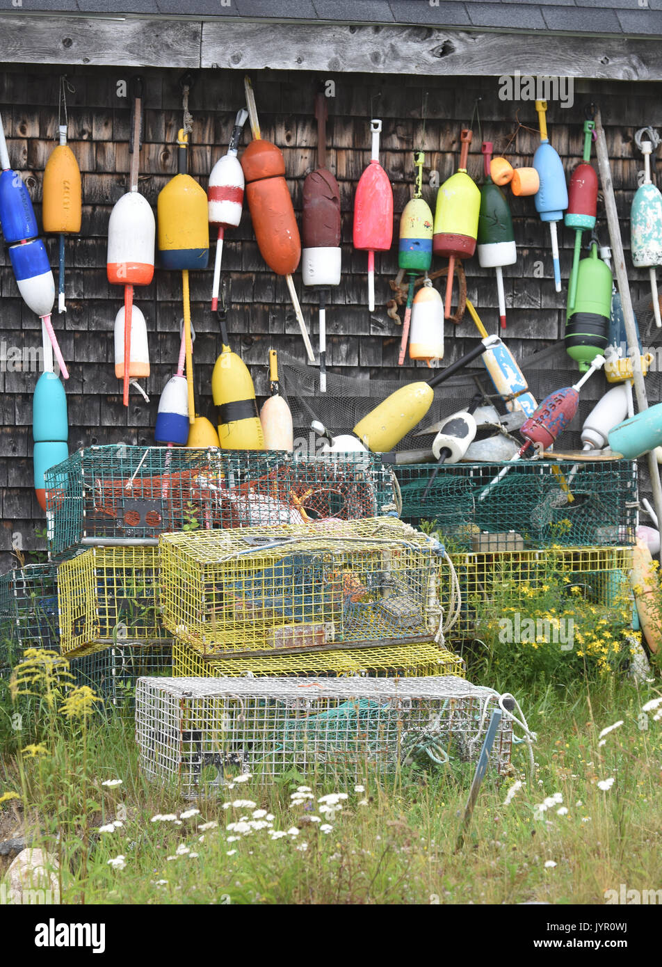 Lobster buoys and traps decorate the side of a barn/boat house in Boothbay, Maine Stock Photo