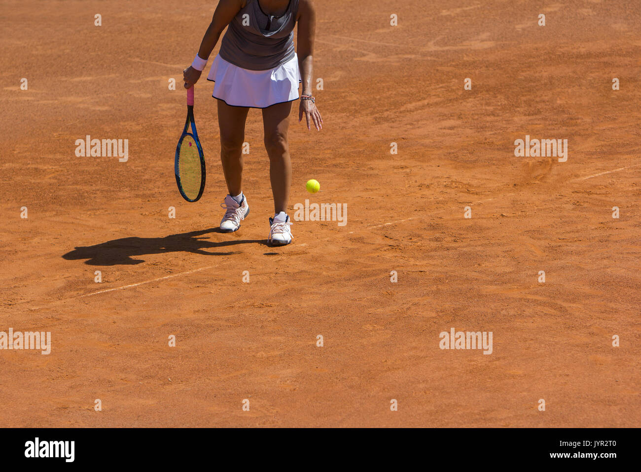 A woman tennis player preparing to serve in tennis cort Stock Photo