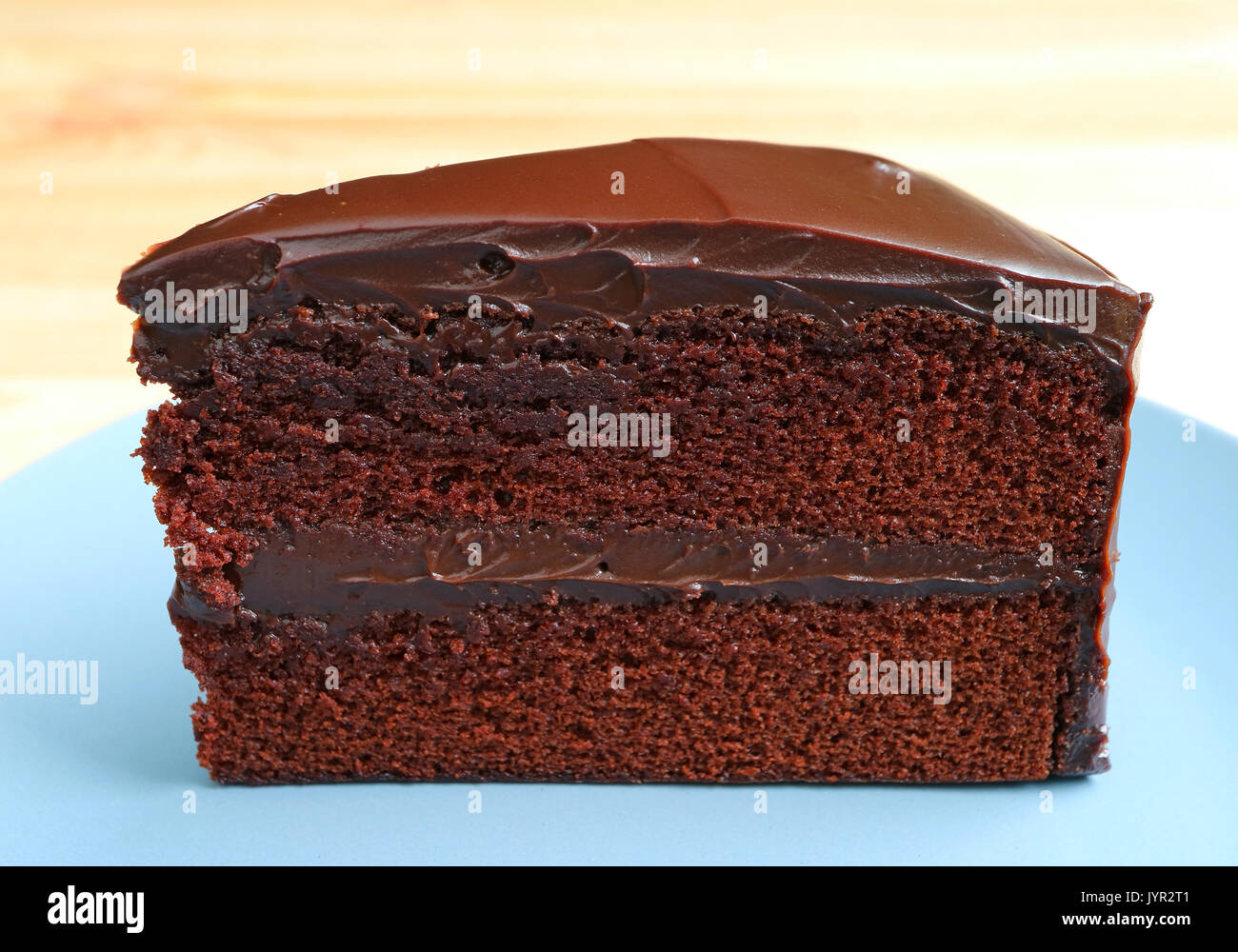 Front view of Chocolate Layer Cake Served on Wooden Table, Blurred Background Stock Photo