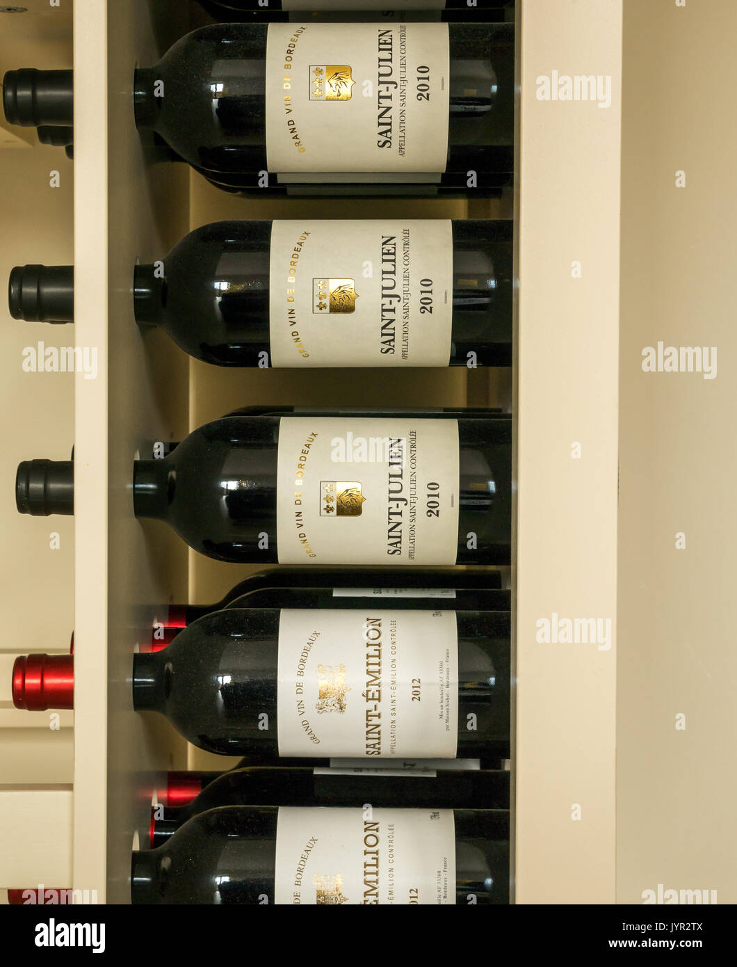 Red wine bottles in a rack from the Bordeaux region of France, including Saint Julien and Saint Emilion Stock Photo