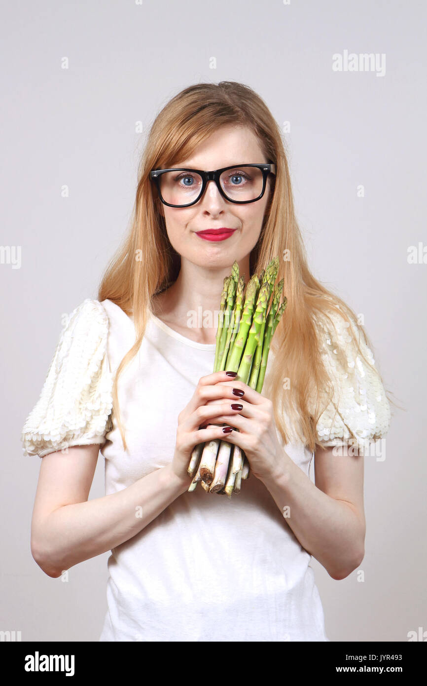 Young woman holding a bunch of asparagus in her hands Stock Photo