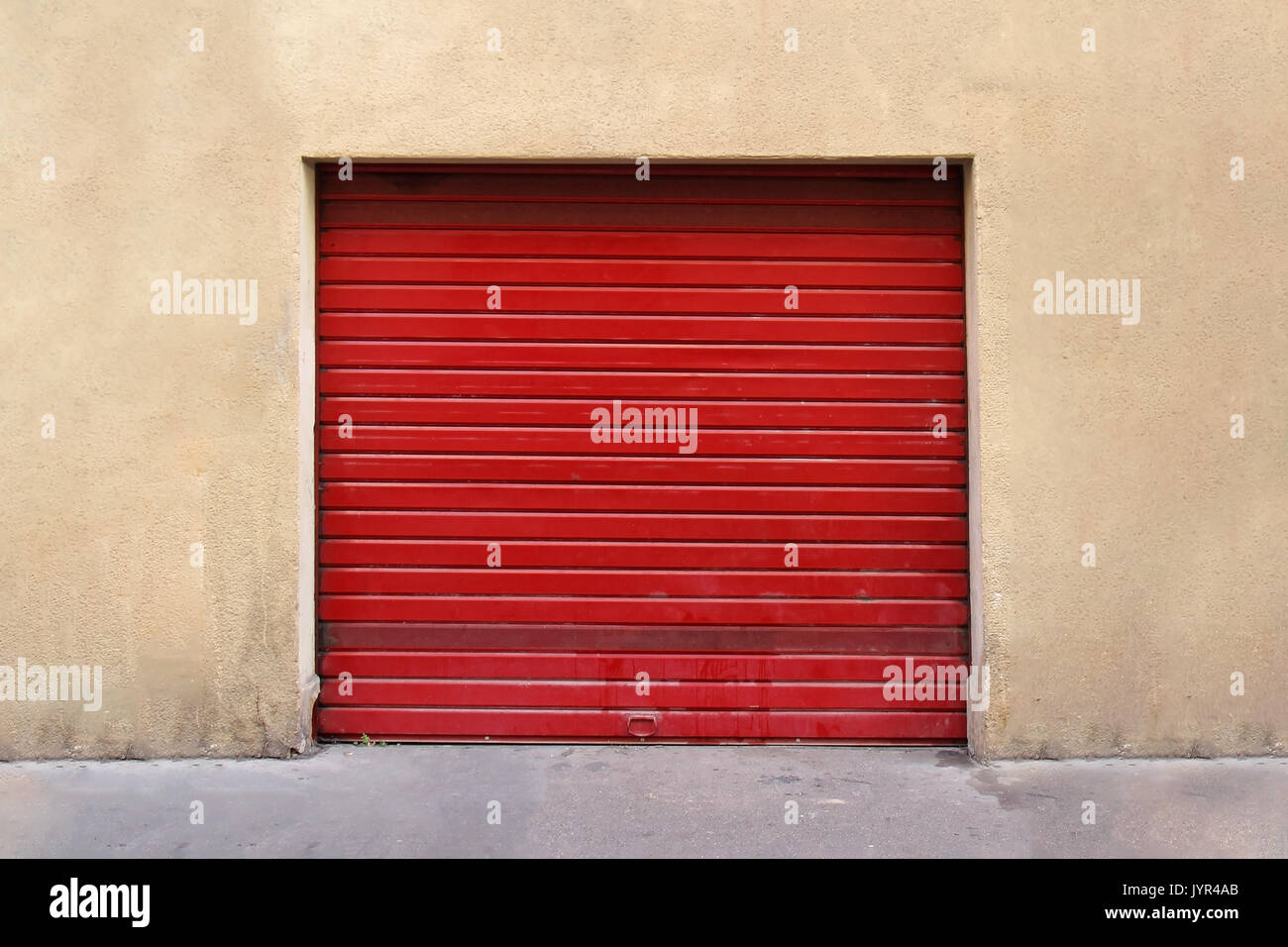 Closed red garage metal roller door exterior Stock Photo