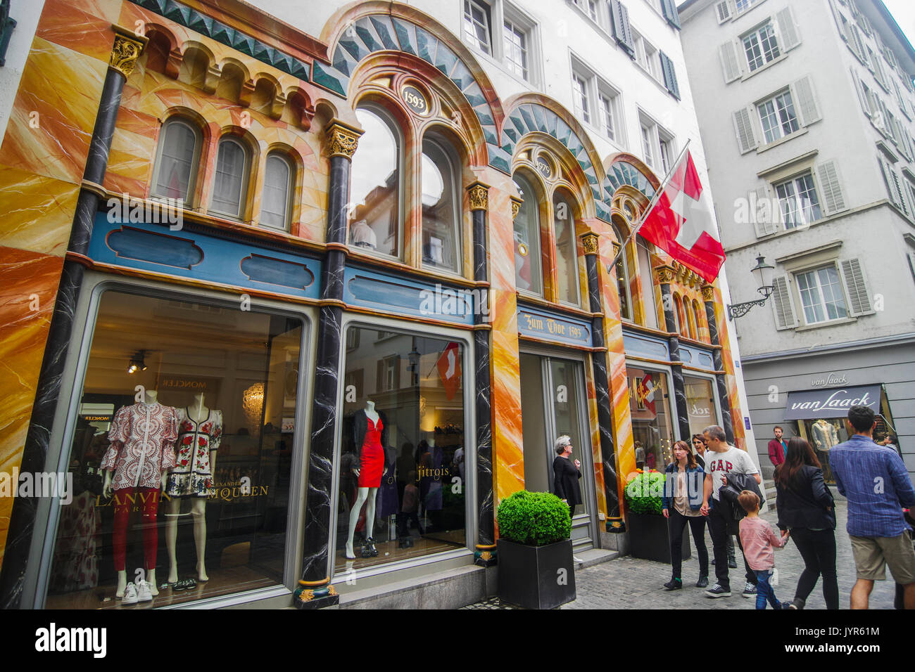 Downtown City scene of narrow shopping street with many Swiss flags