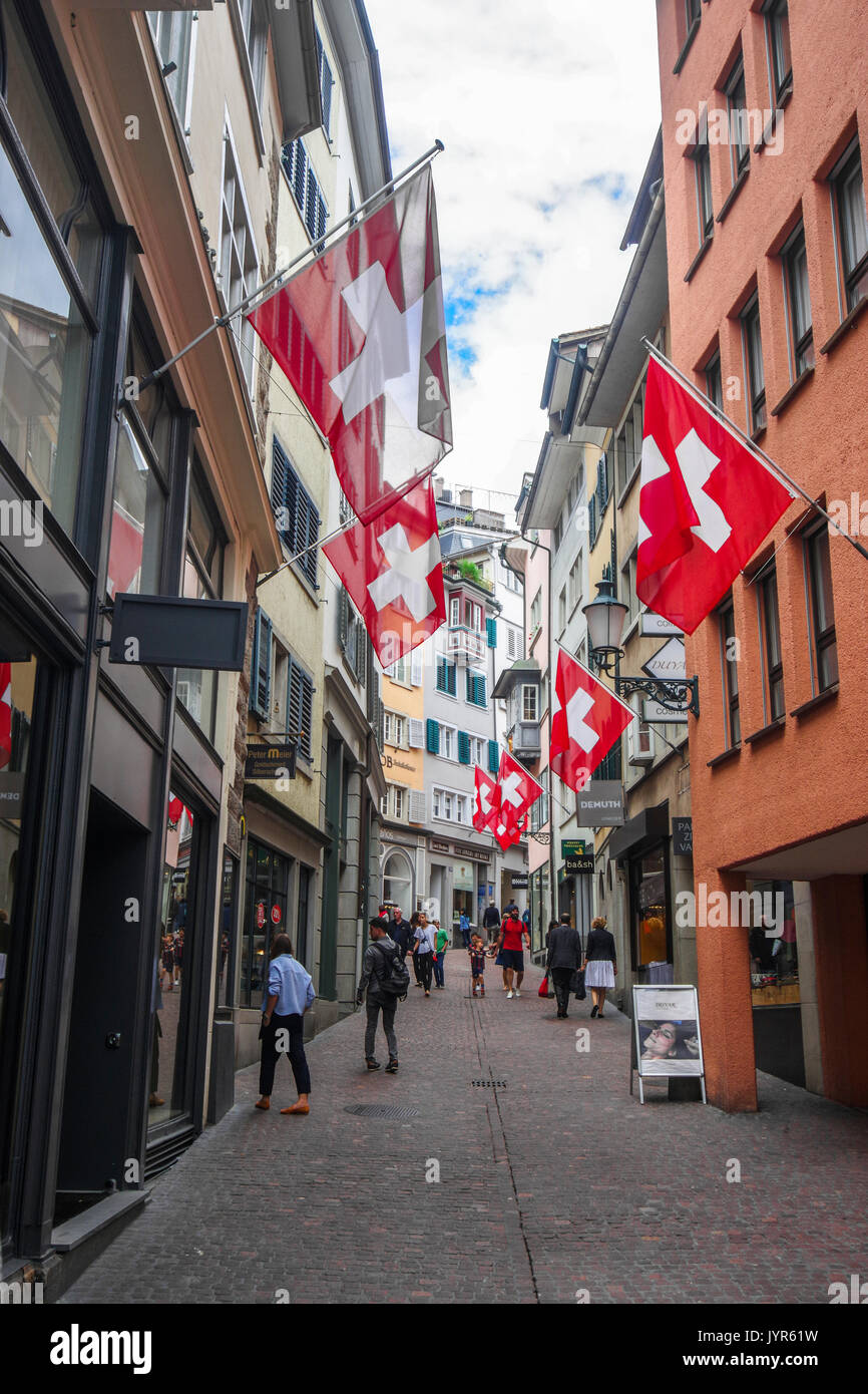 Downtown City scene of narrow shopping street with many Swiss flags from Zurich Switzerland