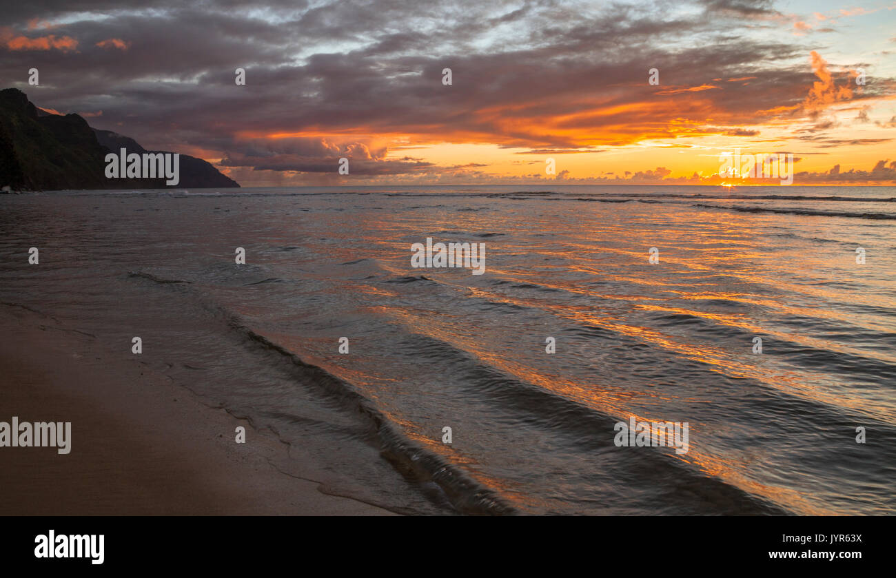 Beautiful sunset at Kee Beach on Kauai, with the Napali Coast in distance Stock Photo