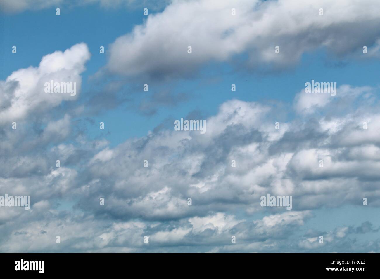 Altocumulus puffy white clouds against a light azure sky Stock Photo