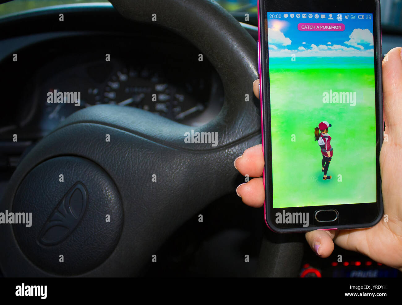 Woman sitting in a car and playing a Pokemon Go game Stock Photo - Alamy