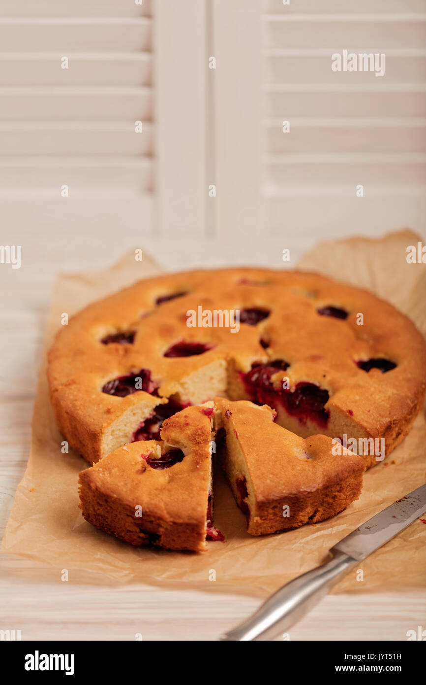 Home plum pie on baking paper. Selective focus. Stock Photo